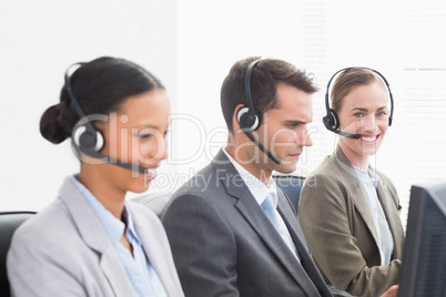 Business people with headsets using computers