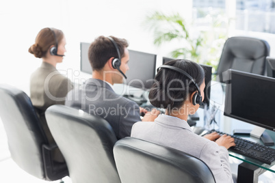 Business people with headsets using computers