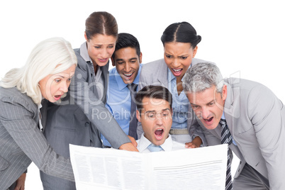 Surprising business people looking at newspaper