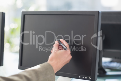 Businesswoman touching computer screen with pen