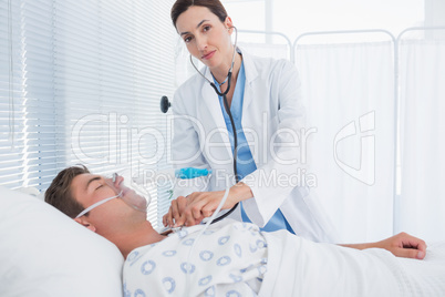 Smiling doctor auscultating her patients chest