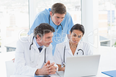 Team of doctors working on laptop computer