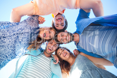 Happy friends standing in circle and looking at camera