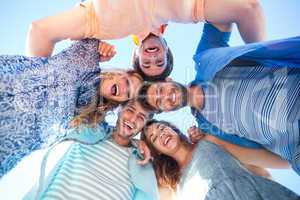 Happy friends standing in circle and looking at camera