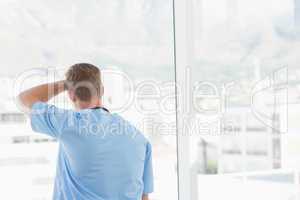 Male doctor looking through windows