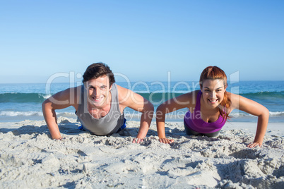 Happy couple doing push ups together