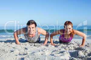 Happy couple doing push ups together