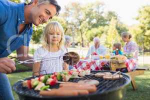 Happy father doing barbecue with her daughter