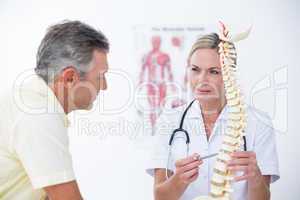 Doctor showing her patient a spine model