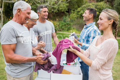 Happy volunteer family separating donations stuffs