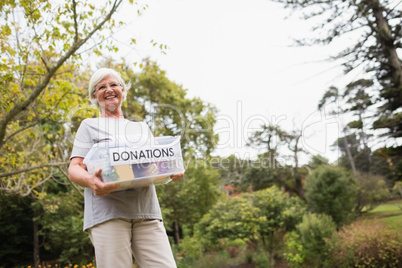 Happy grandmother holding donation box