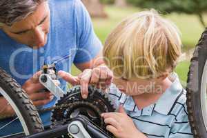 Father and his son fixing a bike