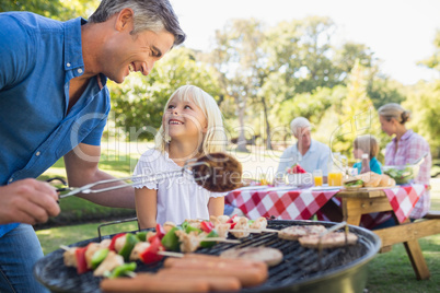 Happy father doing barbecue with her daughter