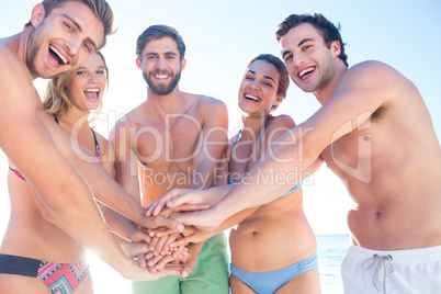 Group of friends standing in circle and smiling at camera