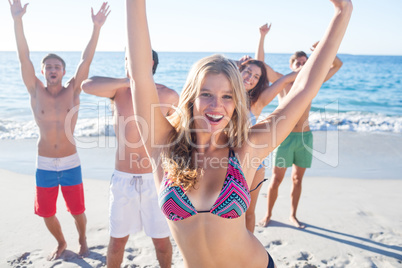 Happy friends dancing on the sand