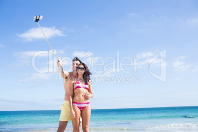 Happy couple taking selfie with selfie stick