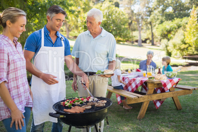 Happy man doing barbecue for his family