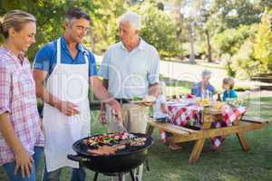 Happy man doing barbecue for his family