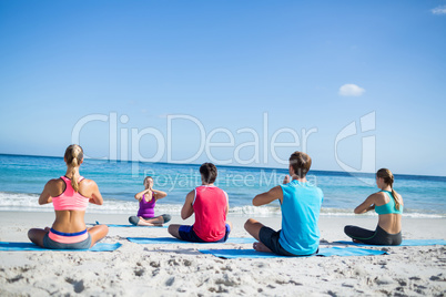 Friends doing yoga together with their teacher