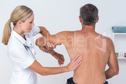 Doctor examining her patient arm