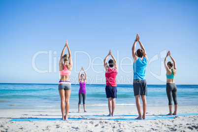 Friends doing yoga together with their teacher