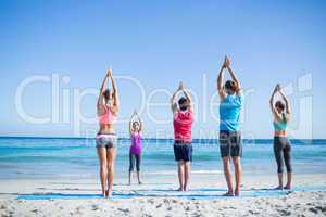 Friends doing yoga together with their teacher