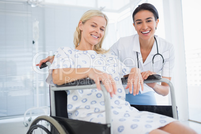 Doctor and patient in wheelchair smiling at camera