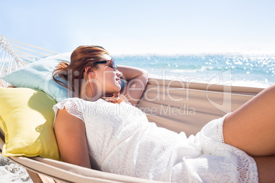 Brunette relaxing in the hammock with sunglasses