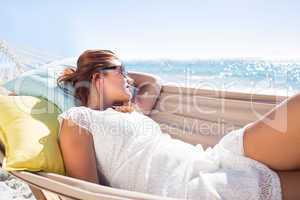 Brunette relaxing in the hammock with sunglasses