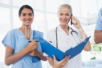 Doctor holding folder and having phone call