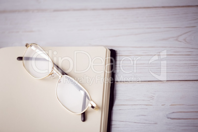 Empty notepad with reading glasses