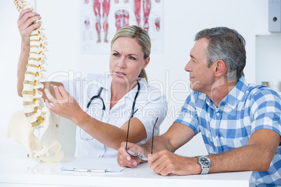 Doctor showing her patient a spine model