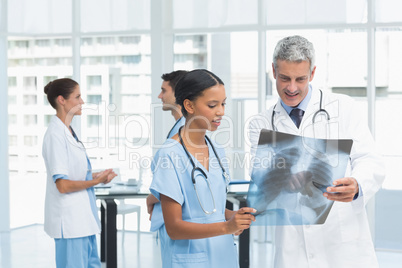 Male and female doctors examining x-ray