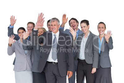 Smiling business team waving at camera