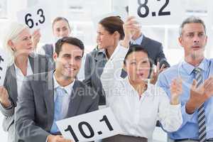 Interview panel holding score cards in office