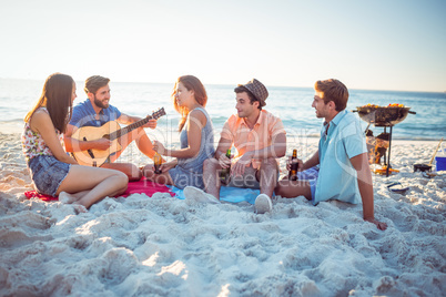 Happy hipsters relaxing and playing guitar