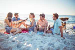 Happy hipsters relaxing and playing guitar