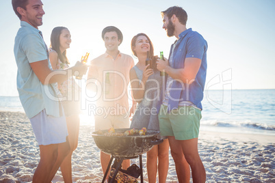 Happy friends doing barbecue and drinking beer