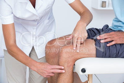 Doctor examining her patient knee