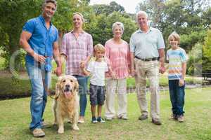 Happy family smiling at the camera with their dog