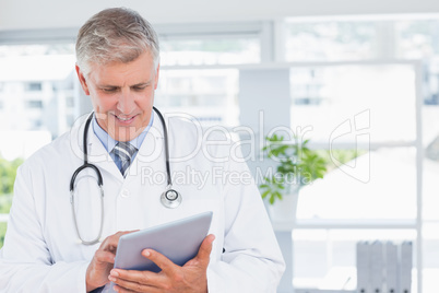 Smiling doctor holding tablet