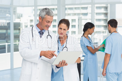 Male and female doctors working on reports