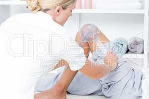 Doctor examining man leg with tool