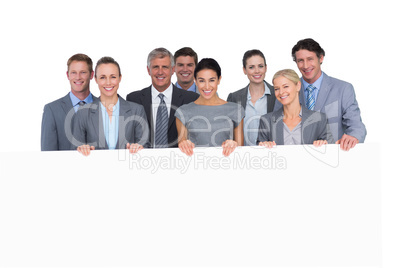 Smiling business team holding poster