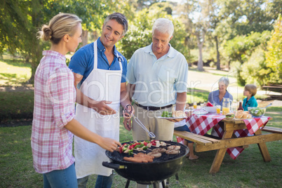 Happy man doing barbecue for his family