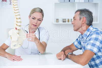 Doctor showing her patient a spine model