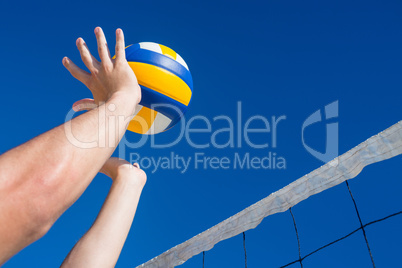 Man throwing volleyball above the net