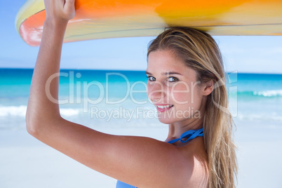 Pretty blonde woman holding surf board