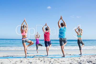 Friends doing yoga together with their teacher