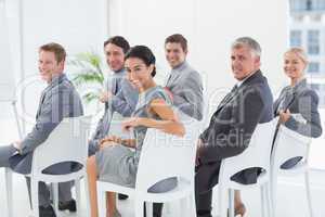 Smiling business team looking at camera during conference